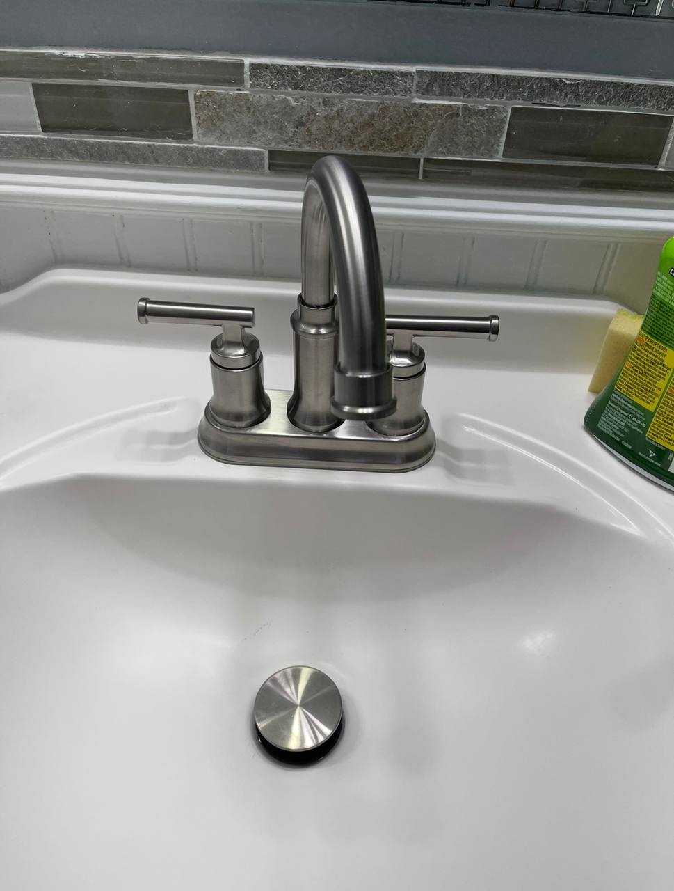 Bathroom sink with a brushed-metal faucet and drain stopper